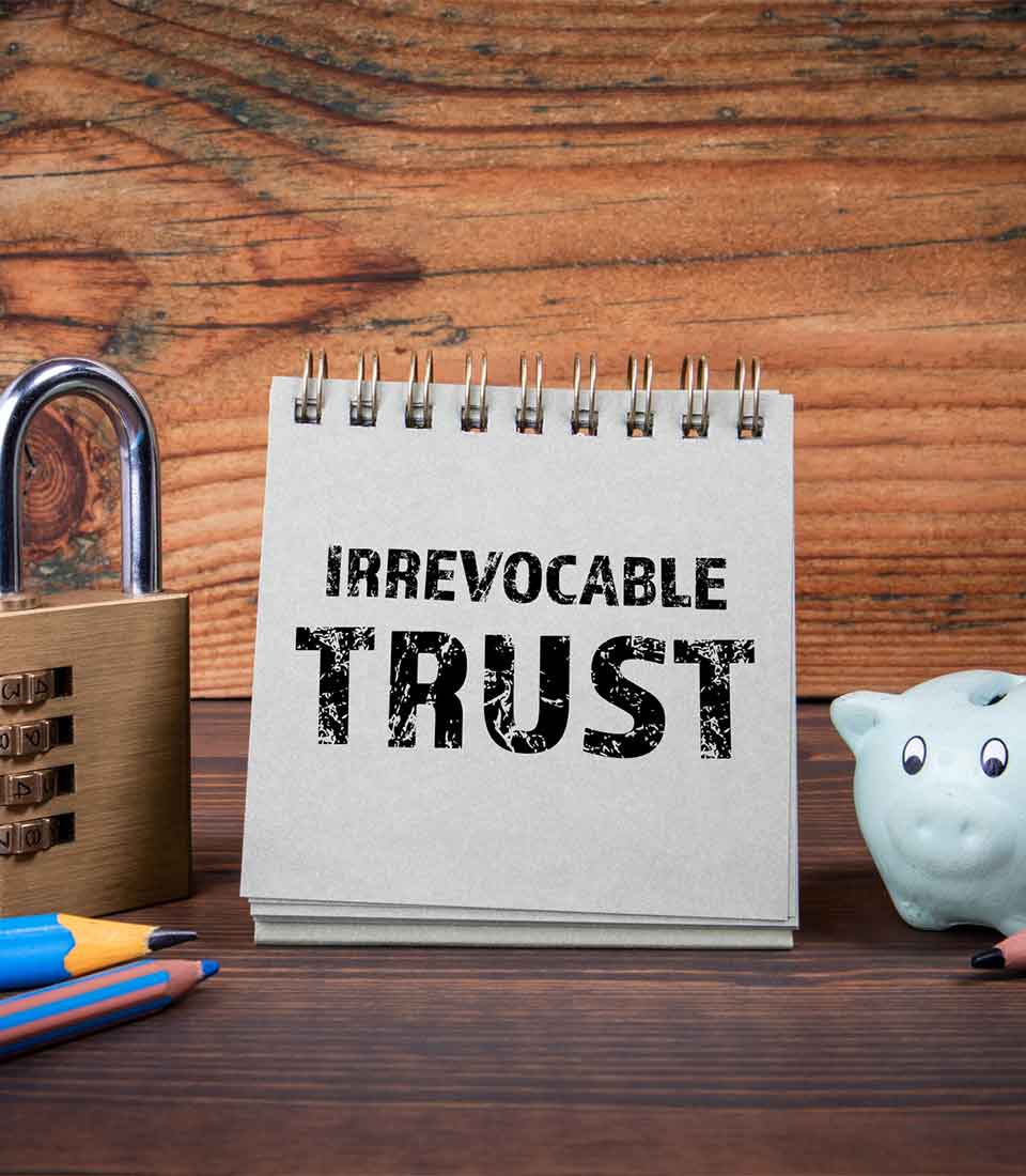 Irrevocable Trust Attorney Denver Notepad labeled Irrevocable Trust with lock and piggy bank - Irrevocable Trust Attorney Denver