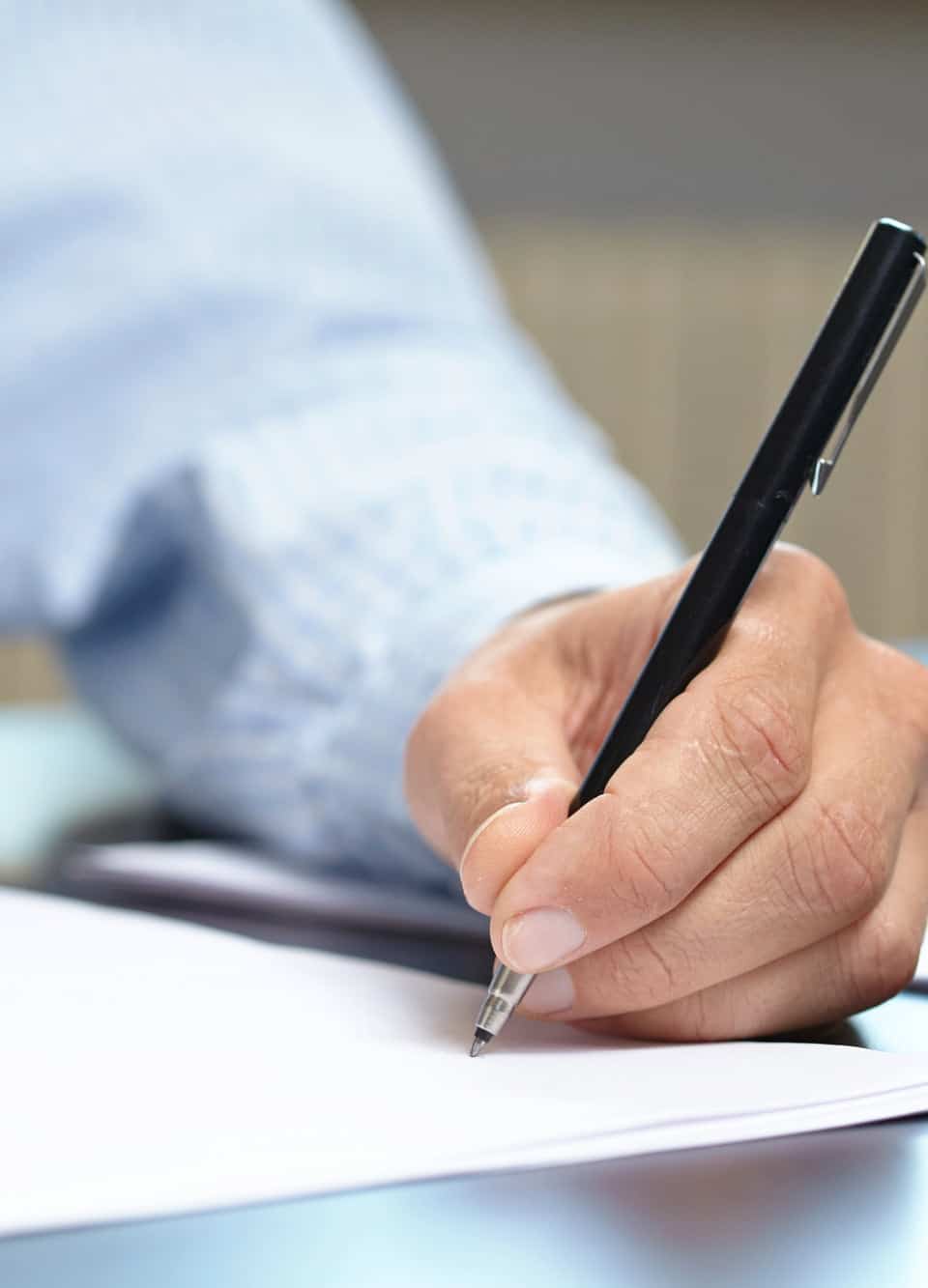 Close-up of hand writing with pen on paper