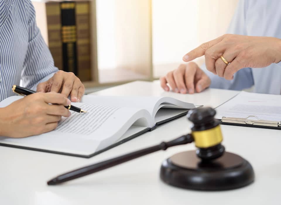 Client signing legal document beside judge's gavel