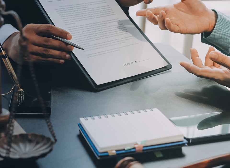Trust Attorney Denver Two people reviewing and signing a document - Trust Attorney Denver