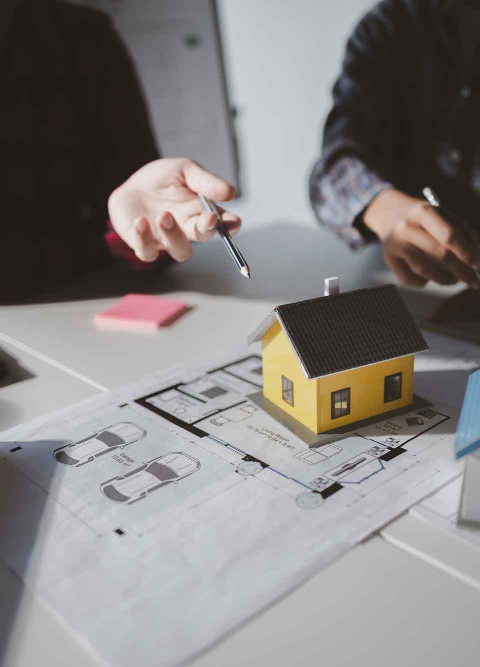 Estate Planning Attorney Denver Model house on blueprints during planning meeting