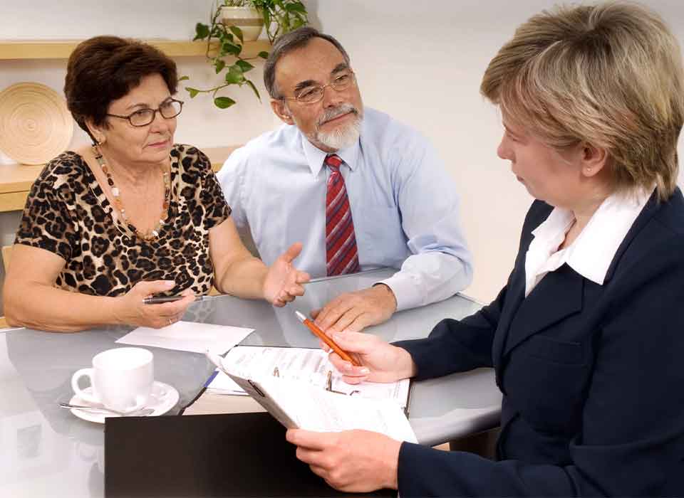 Wills Attorney Denver Senior couple meeting with financial advisor at table - Wills Attorney Denver